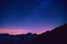 Night sky filled with stars and mountain silhouette.