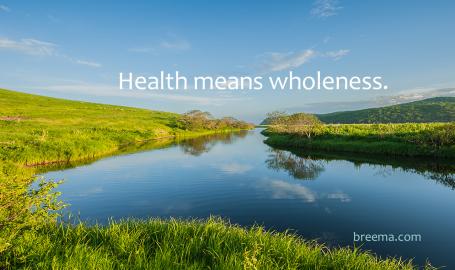 A reflective pond in a green valley with clear blue skies