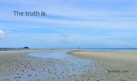 A dry tidal stream on the coast under a clear expansive sky