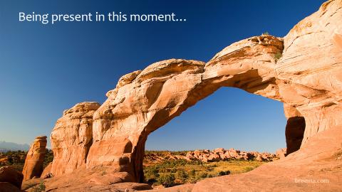 Natural arch in sandstone formation against clear sky.