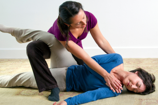 Salena Irion practicing Breema bodywork on the floor