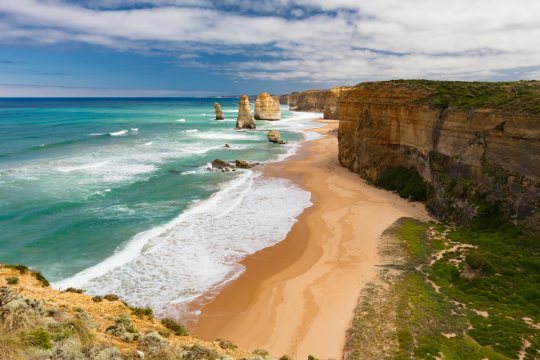 Sun pierced clouds over the 12 Apostles rock formations in Australia.