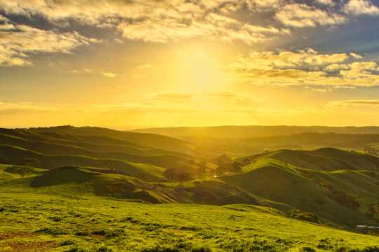 A view of the sun setting over the hills in California.