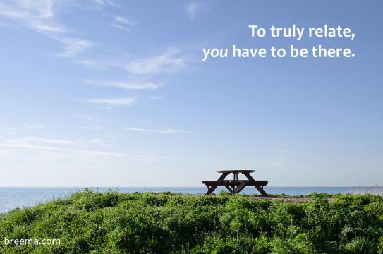 Empty picnic table on a hill over the water with clear blue sky overhead